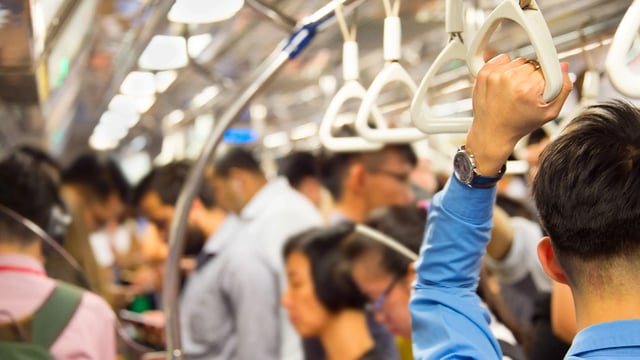 Commuters holding handle supports on the train. Mass transit audio, loudspeaker design concept.